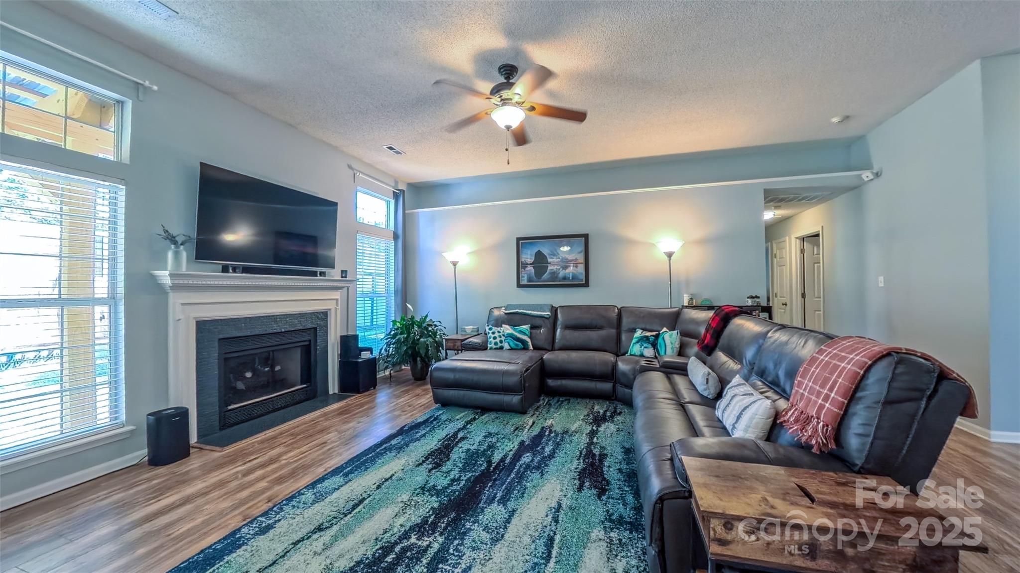 3693 Stonefield Street Southwest Concord, NC 28027 - Photo 7 of 27 a living room with furniture a fireplace and a flat screen tv