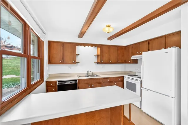 a kitchen with a refrigerator a stove and a sink