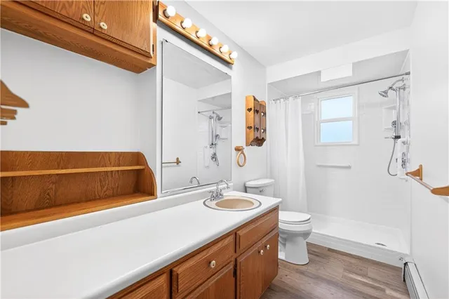 a bathroom with a sink a toilet and shower