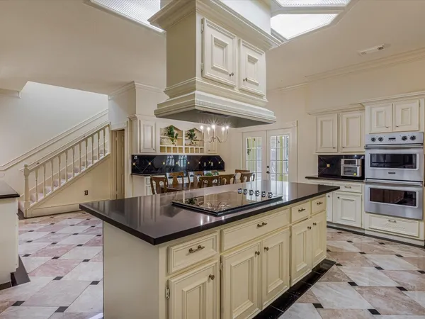 a large kitchen with kitchen island a dining table and chairs
