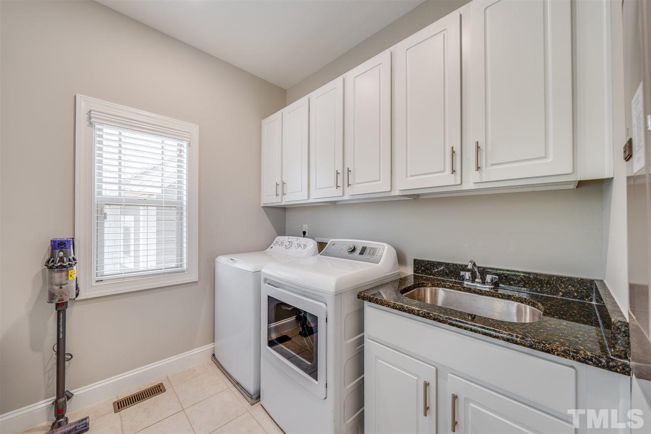 1338 Rodessa Run Raleigh, NC 27607 - Photo 22 of 27 Convenient second floor laundry with sink and cabinets for clutter free look