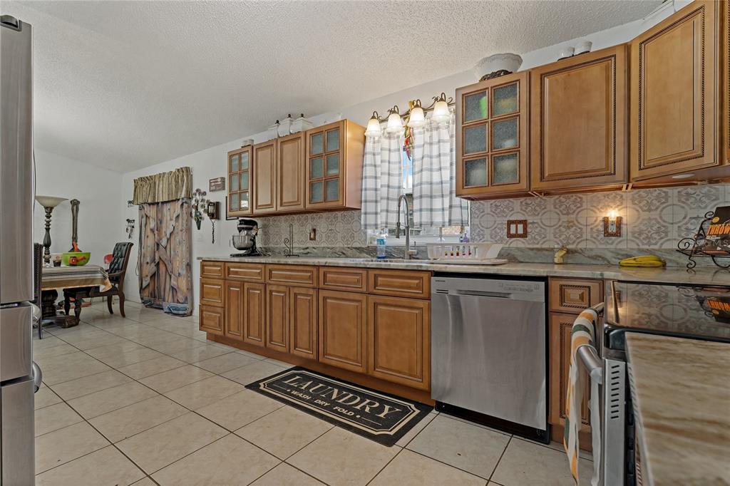 208 Limpkin Lane Frostproof, FL 33843 - Photo 21 of 60 a kitchen with stainless steel appliances granite countertop a sink stove and cabinets