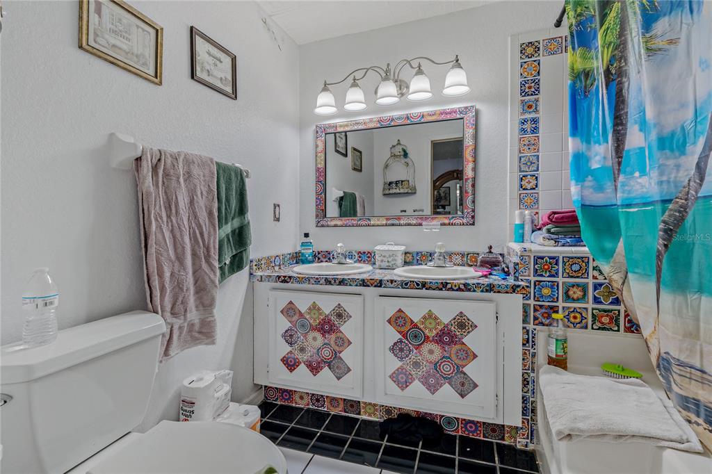 208 Limpkin Lane Frostproof, FL 33843 - Photo 29 of 60 a bathroom with a sink a toilet and shower curtain