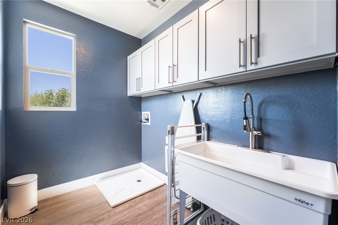 2166 Trivero Street Henderson, NV 89044 - Photo 32 of 61 Ample storage and a utility sink create a highly functional and efficient laundry space.