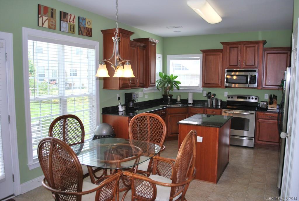 8612 Ridgeline Lane Charlotte, NC 28269 - Photo 8 of 20 a kitchen with stainless steel appliances a stove a sink a dining table and chairs