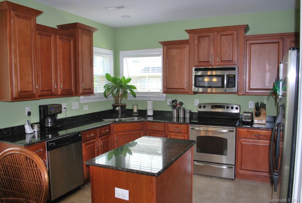 8612 Ridgeline Lane Charlotte, NC 28269 - Photo 10 of 20 a kitchen with stainless steel appliances granite countertop wooden cabinets a stove a sink and a microwave