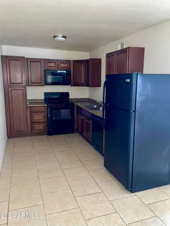 a kitchen with granite countertop stainless steel appliances a stove a microwave and sink