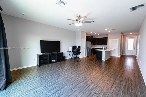 a view of a livingroom with furniture wooden floor and a flat screen tv