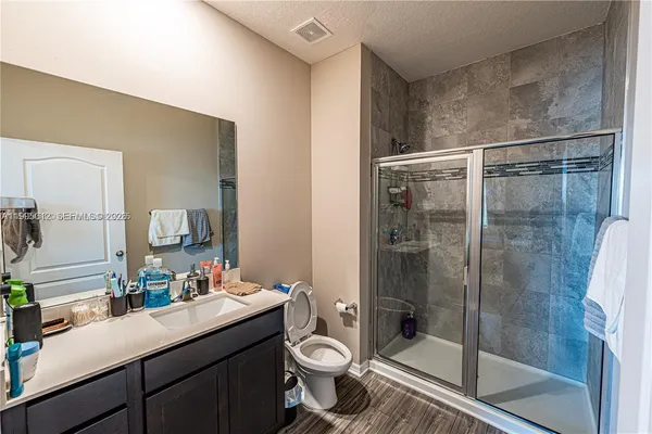 a bathroom with a shower sink mirror and toilet