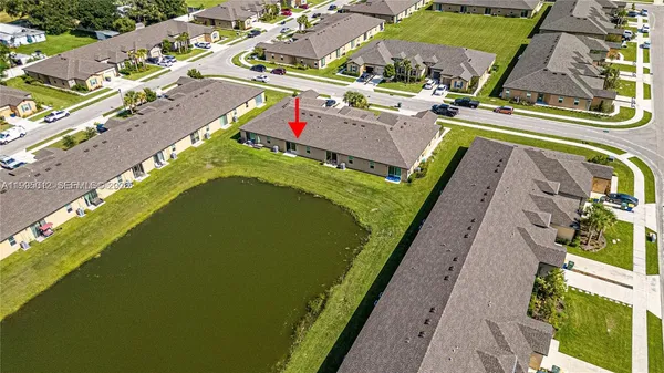 an aerial view of a swimming pool with a yard and seating area