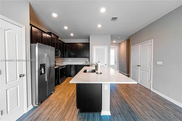 a large kitchen with stainless steel appliances kitchen island a refrigerator sink and cabinets