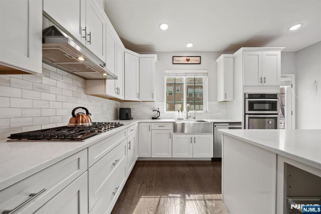 129 Truman Drive Wood-Ridge, NJ 07075 - Photo 18 of 47 a kitchen with white cabinets and appliances