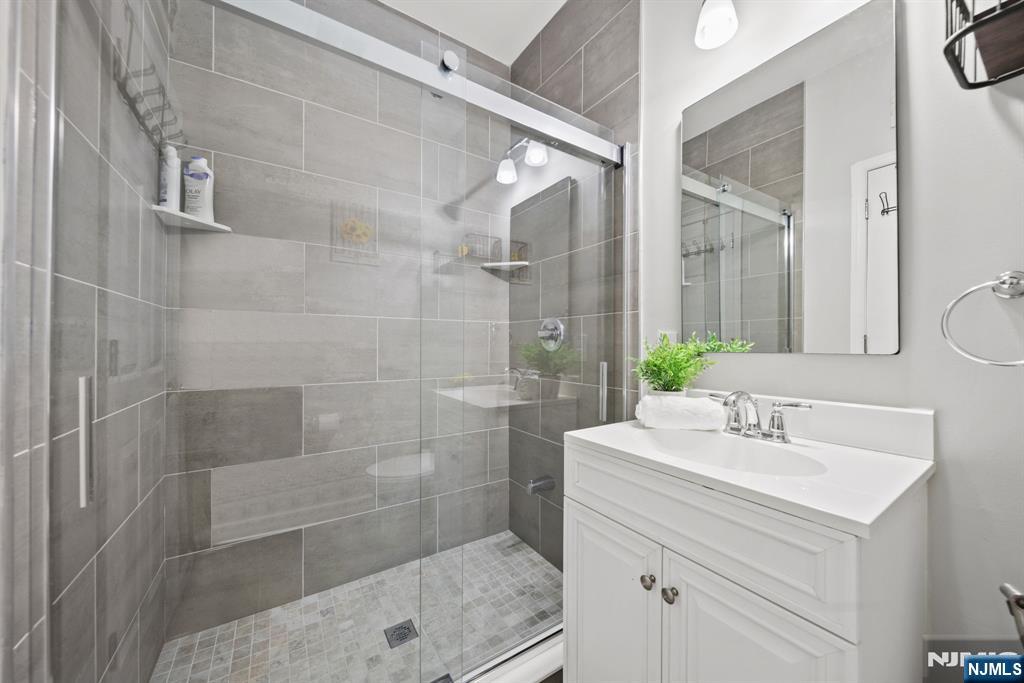 129 Truman Drive Wood-Ridge, NJ 07075 - Photo 9 of 47 a bathroom with a shower sink and mirror