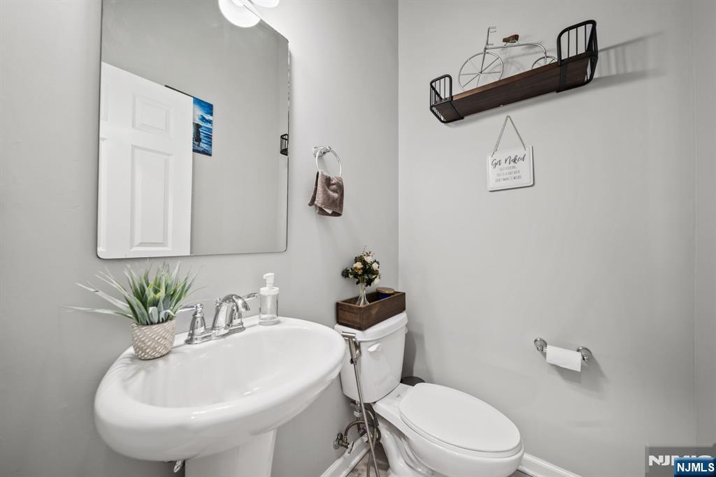 129 Truman Drive Wood-Ridge, NJ 07075 - Photo 10 of 47 a bathroom with a sink a toilet and mirror