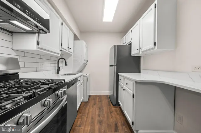 a kitchen with stainless steel appliances a sink stove and cabinets