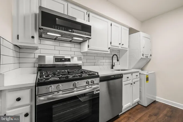 a kitchen with stainless steel appliances a sink a stove and cabinets