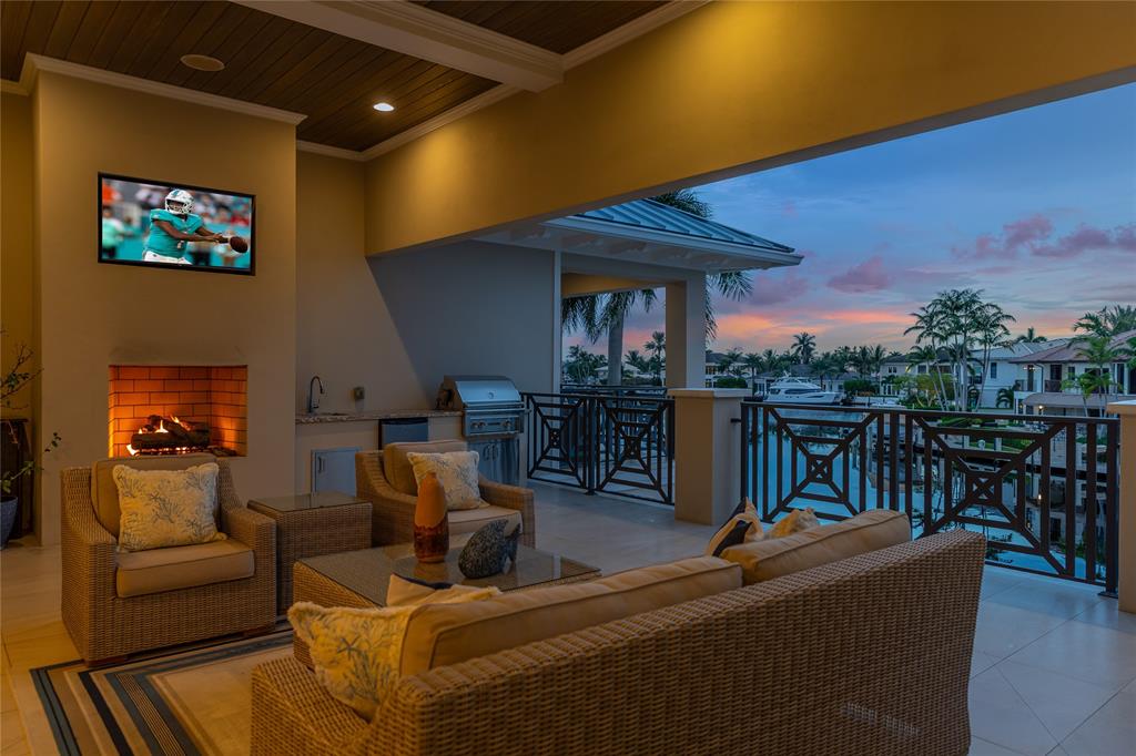 3211 Northeast 27th Avenue Lighthouse Point, FL 33064 - Photo 62 of 98 a living room with furniture a kitchen view and a fireplace