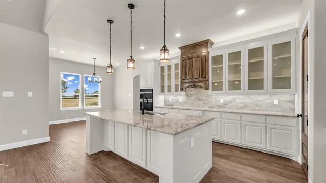 a kitchen with stainless steel appliances granite countertop a sink a window and a counter top space