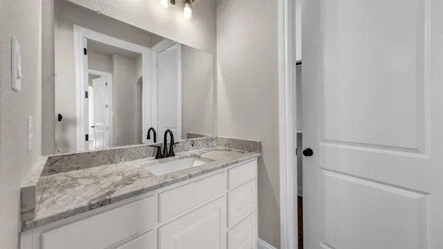 a bathroom with a granite countertop sink and a mirror