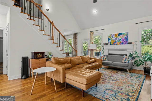 a living room with furniture a rug and a dining table