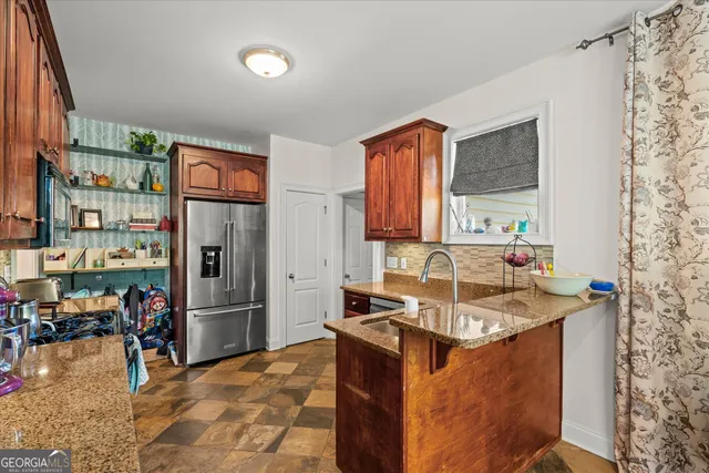 a view of a kitchen with fridge and workspace