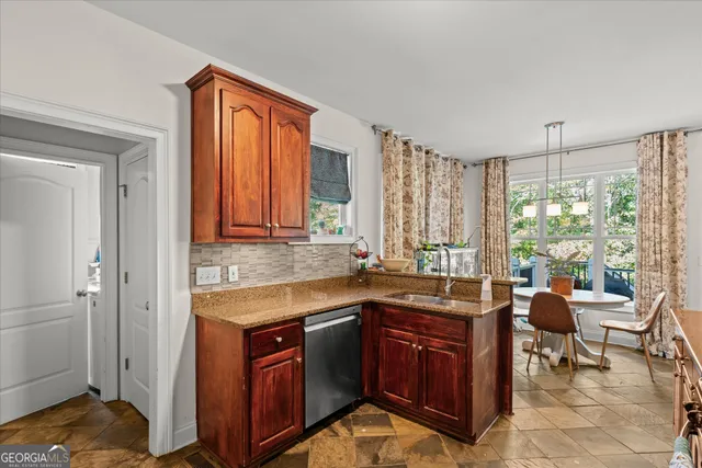 a kitchen with stainless steel appliances granite countertop a stove a sink and a microwave