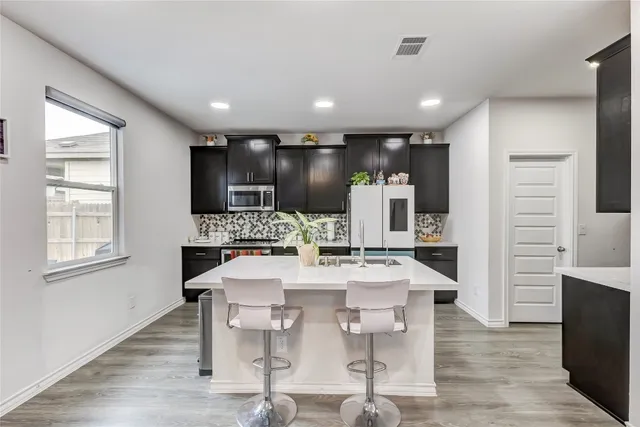 a large kitchen with a table and chairs