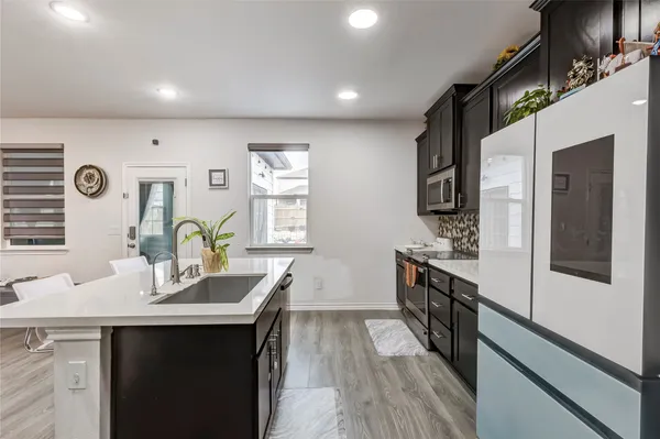a kitchen with stainless steel appliances granite countertop a sink stove and refrigerator