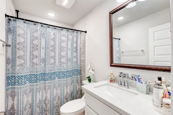 a bathroom with a sink vanity mirror and toilet