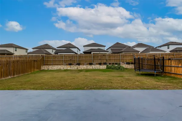 a view of a large pool with lawn chairs under an umbrella