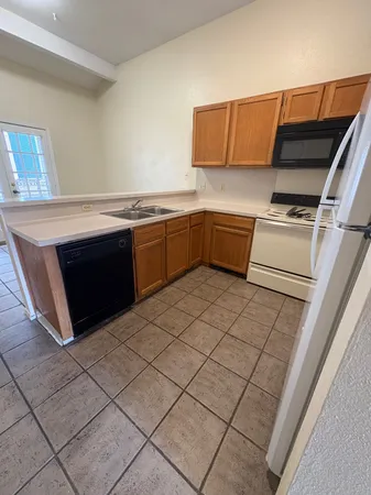 a kitchen with granite countertop a sink and a stove top oven