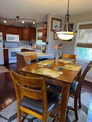 a kitchen with a table chairs and a wooden floor