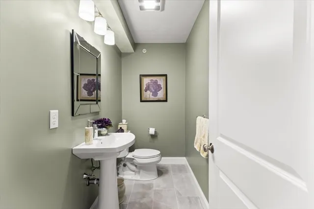a bathroom with a sink mirror and toilet