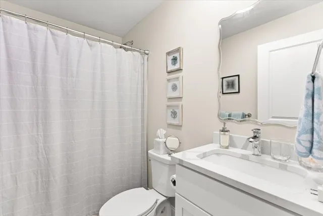 a bathroom with a granite countertop sink toilet and a mirror