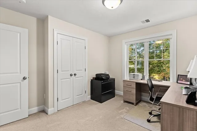 a view of a workspace with furniture and a window