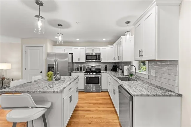 a kitchen with stainless steel appliances granite countertop sink stove top oven and refrigerator