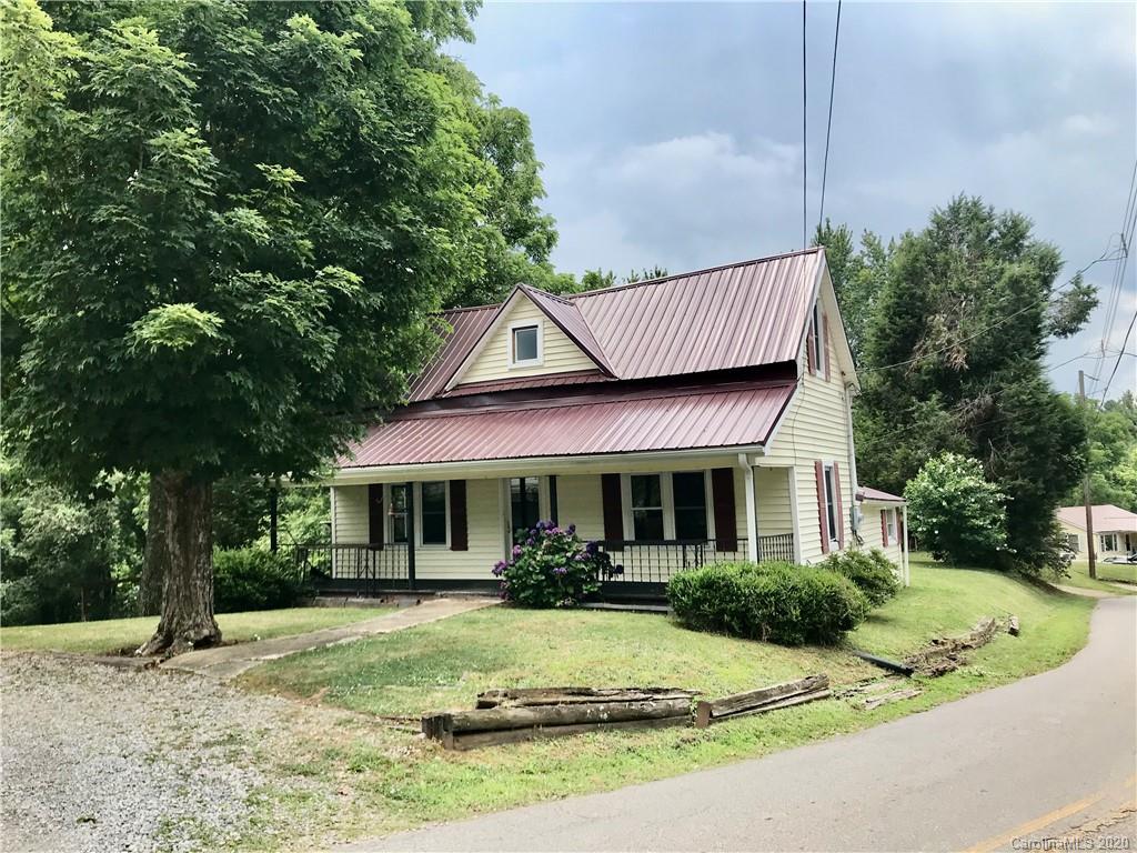 684 Holtzclaw Road Canton, NC 28716 - Photo 1 of 33 a view of a white house with a large tree and a yard with plants and large trees