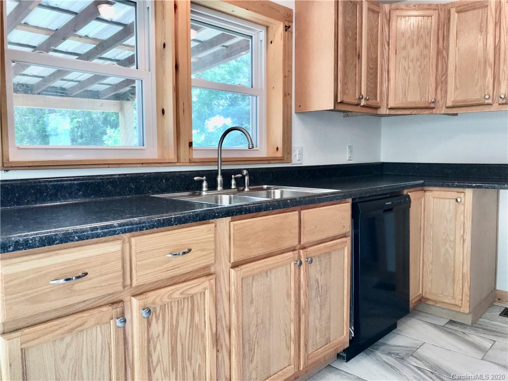 684 Holtzclaw Road Canton, NC 28716 - Photo 14 of 33 a kitchen with granite countertop white cabinets and sink