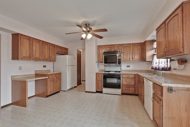 601 West Golf Road Libertyville, IL 60048 - Photo 7 of 27 a kitchen with stainless steel appliances granite countertop a stove top oven a sink dishwasher and a refrigerator with wooden cabinets