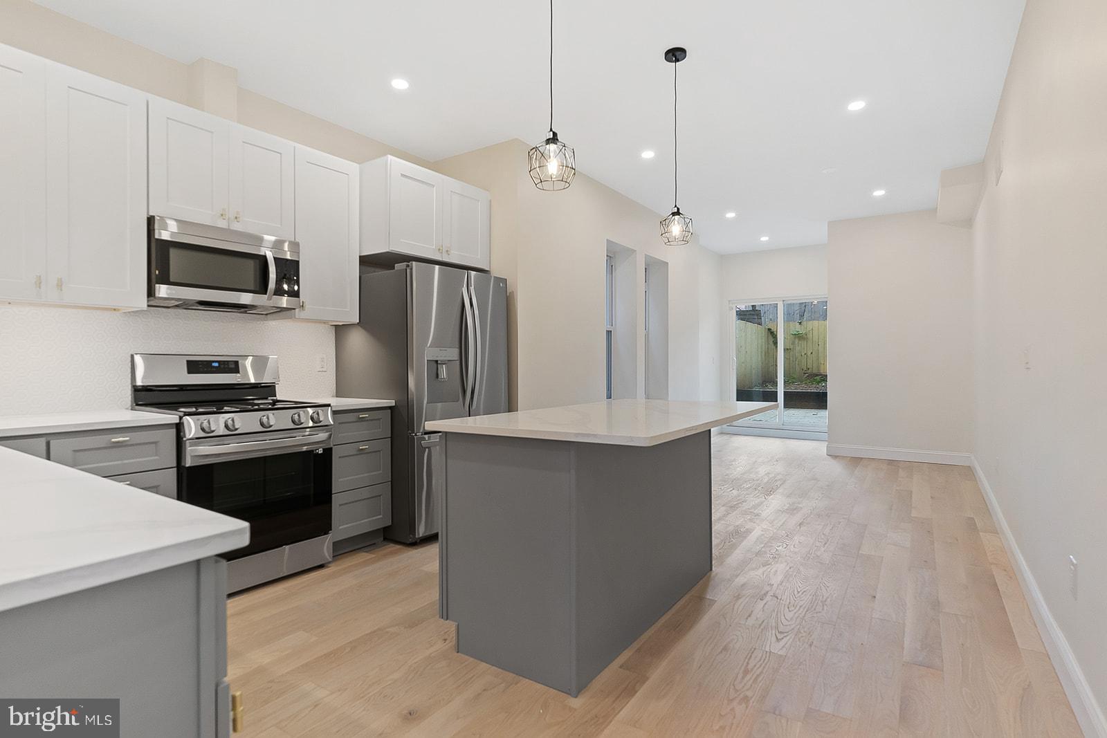 1644 North 6th Street Philadelphia, PA 19122 - Photo 11 of 52 a large kitchen with stainless steel appliances kitchen island granite countertop a refrigerator a stove top oven a sink and dishwasher