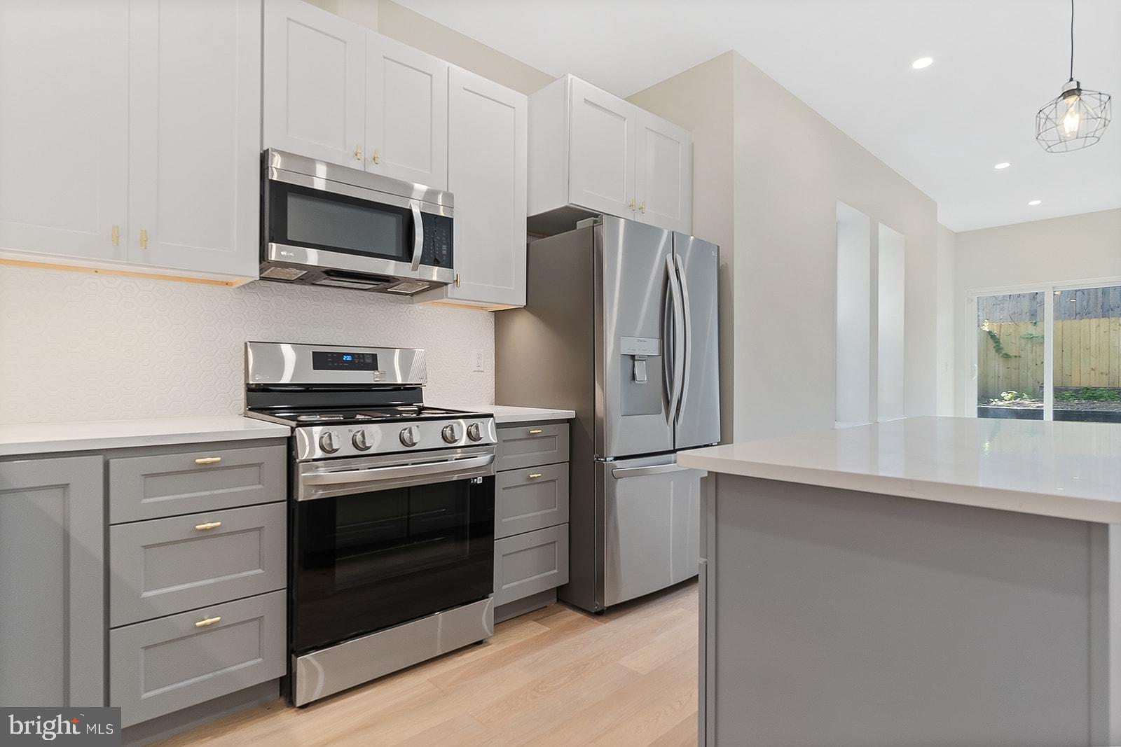 1644 North 6th Street Philadelphia, PA 19122 - Photo 16 of 52 a kitchen with stainless steel appliances a stove a refrigerator and a microwave