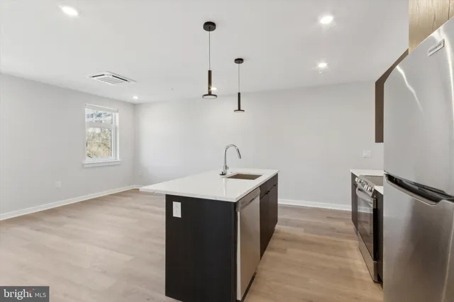 a kitchen with a sink a refrigerator and window
