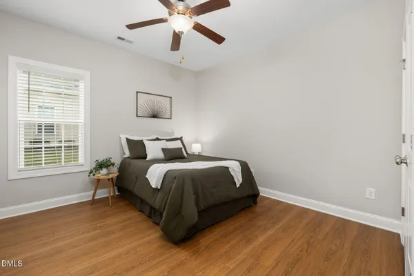 a bedroom with a bed and wooden floor