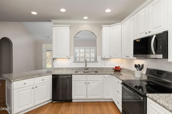 a kitchen with granite countertop a sink stainless steel appliances and cabinets