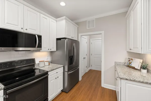 a kitchen with a refrigerator stove and cabinets