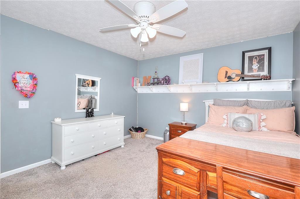 25 Browning Shoals Road Social Circle, GA 30025 - Photo 25 of 47 a bedroom with a bed and a chandelier