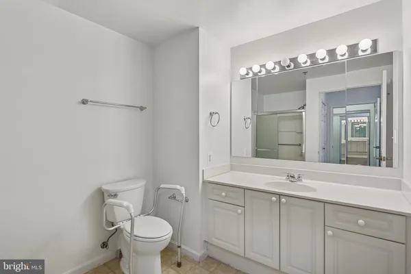 a bathroom with a sink vanity mirror and toilet