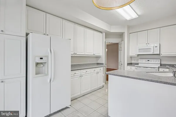 a kitchen with stainless steel appliances granite countertop a refrigerator sink and cabinets