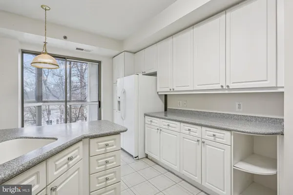 a kitchen with white cabinets and white appliances
