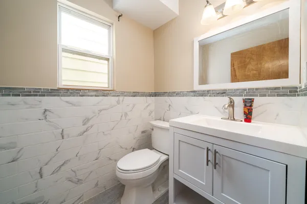 a bathroom with a sink a toilet and a mirror